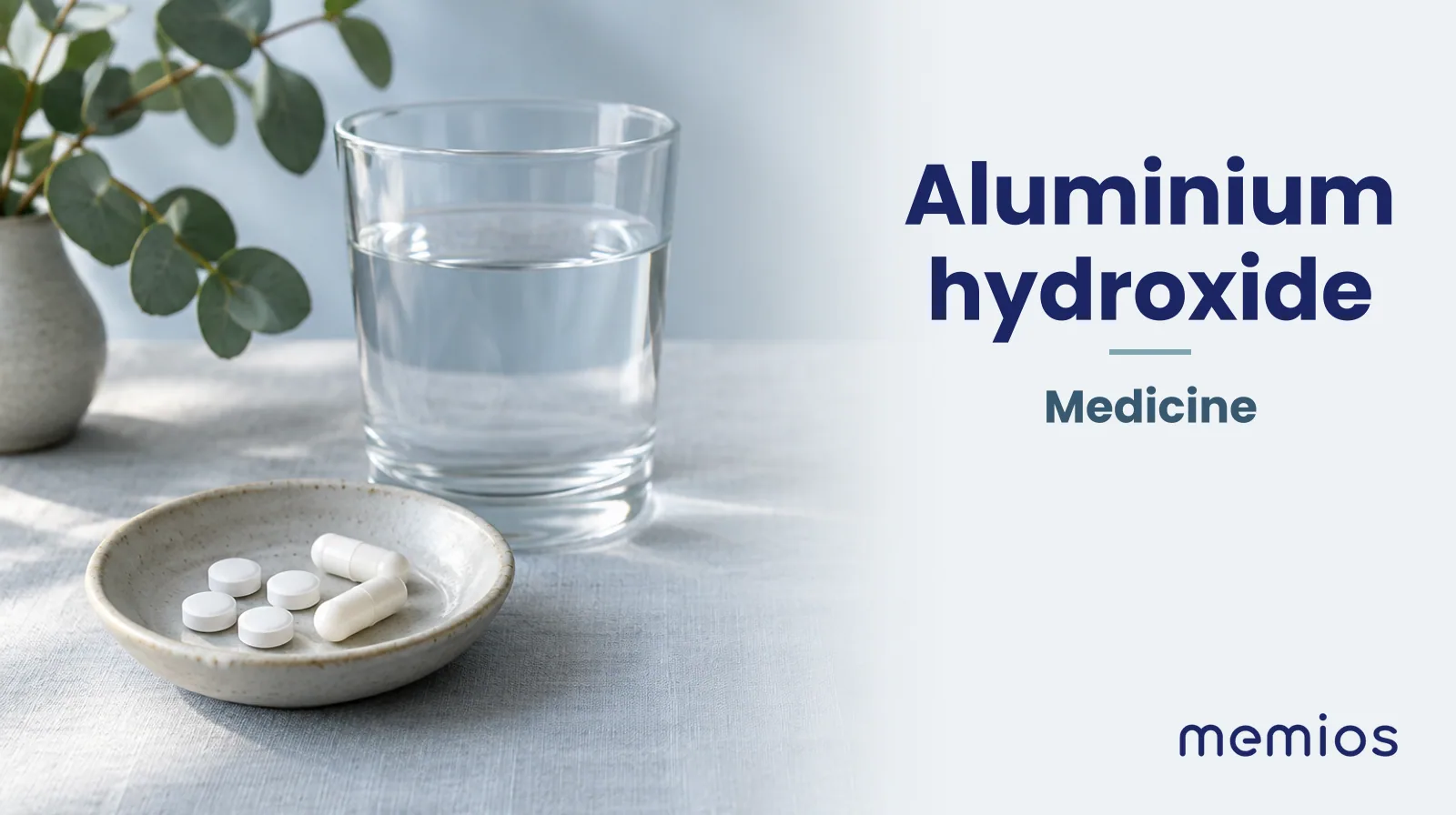 Photograph for Aluminium hydroxide: plain unmarked tablets in a dish beside a glass of water on pale linen.