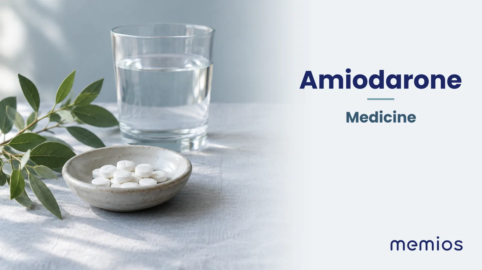 Photograph for Amiodarone: plain unmarked tablets in a dish beside a glass of water on pale linen.