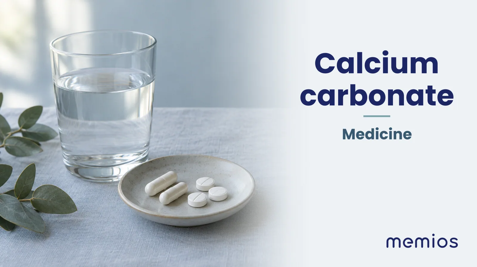 Photograph for Calcium carbonate: plain unmarked tablets in a dish beside a glass of water on pale linen.