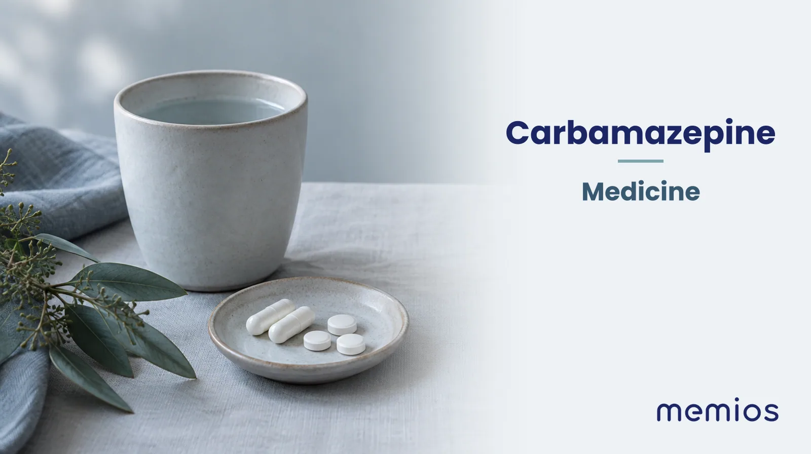 Photograph for Carbamazepine: plain unmarked tablets in a dish beside a glass of water on pale linen.
