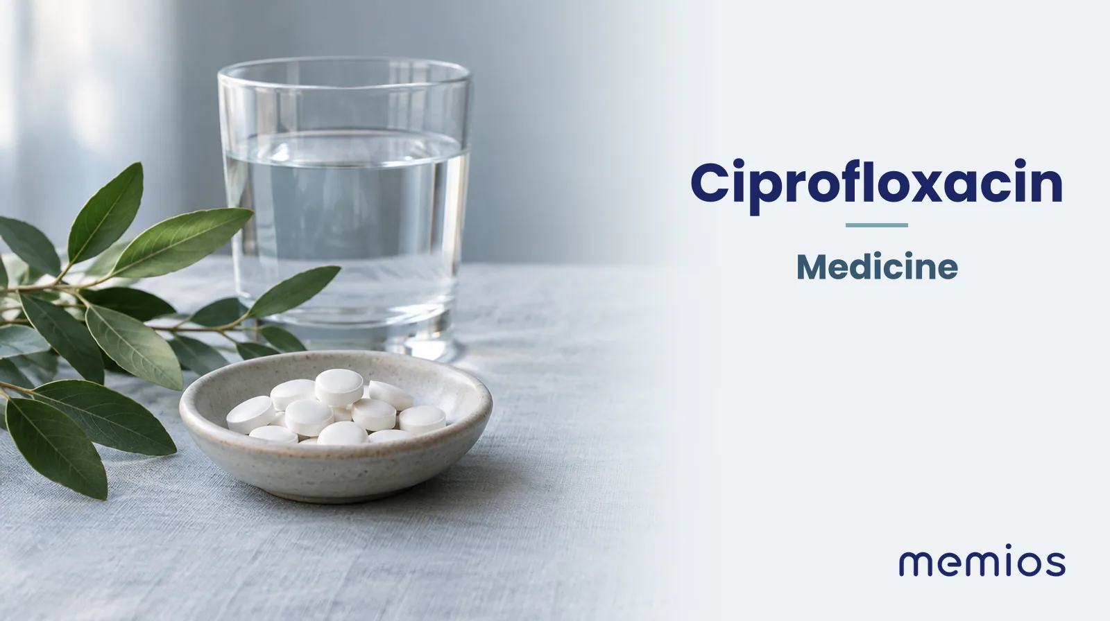 Photograph for Ciprofloxacin: plain unmarked tablets in a dish beside a glass of water on pale linen.