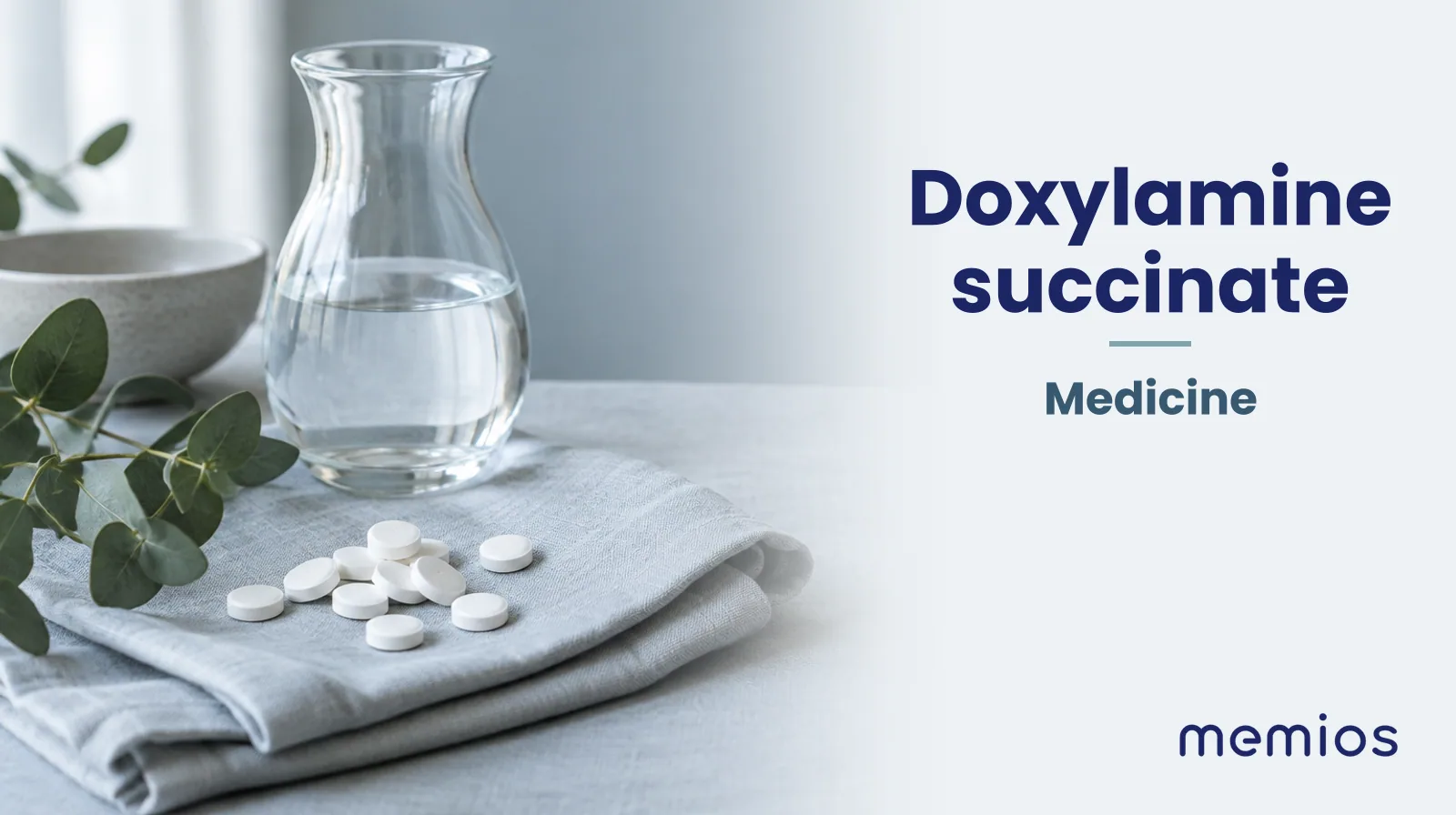 Photograph for Doxylamine succinate: plain unmarked tablets in a dish beside a glass of water on pale linen.