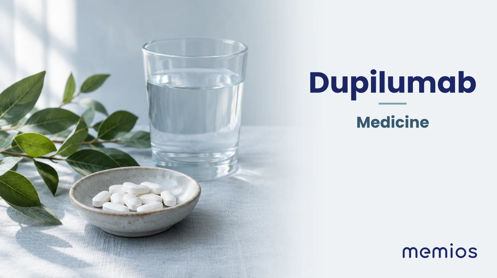 Photograph for Dupilumab: plain unmarked tablets in a dish beside a glass of water on pale linen.