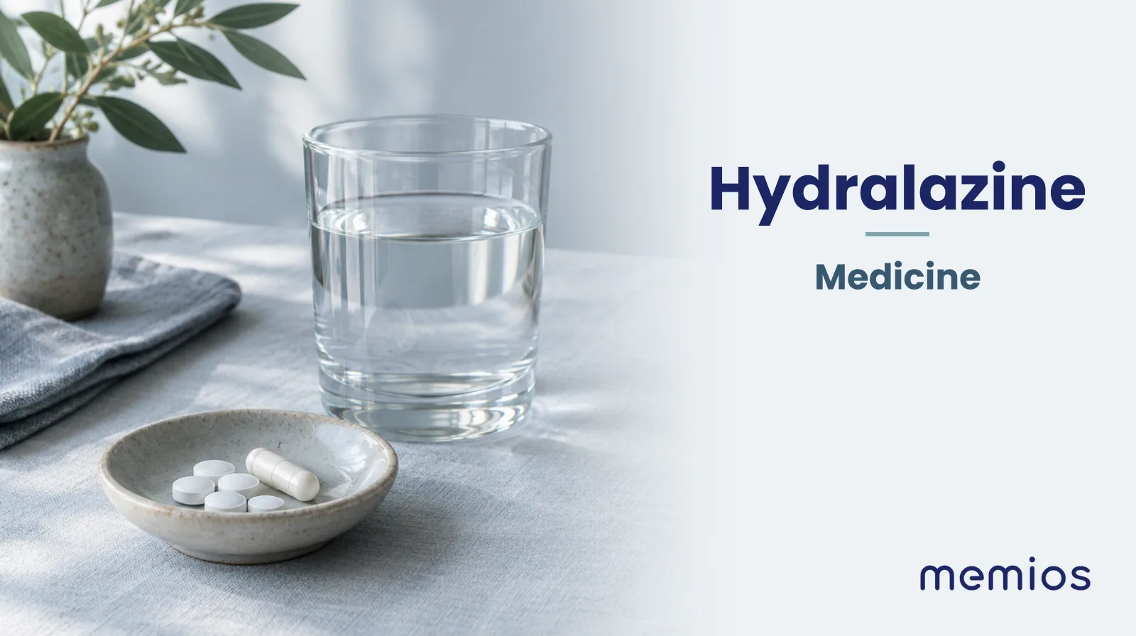 Photograph for Hydralazine: plain unmarked tablets in a dish beside a glass of water on pale linen.