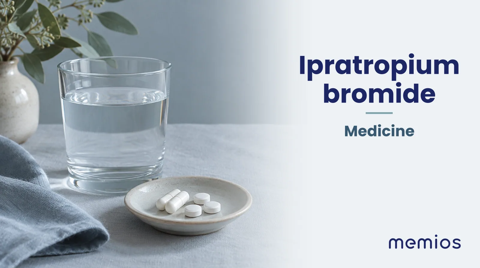 Photograph for Ipratropium bromide: plain unmarked tablets in a dish beside a glass of water on pale linen.