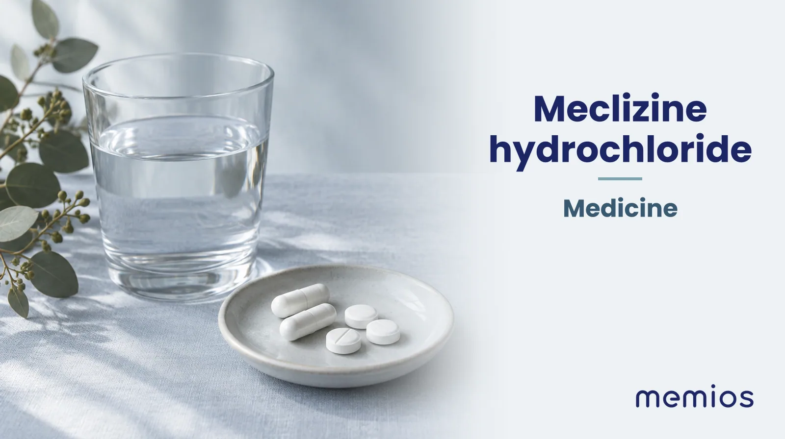 Photograph for Meclizine hydrochloride: plain unmarked tablets in a dish beside a glass of water on pale linen.