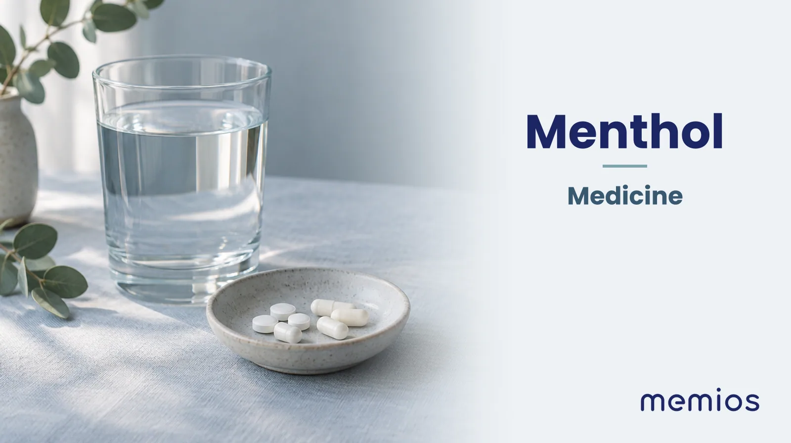 Photograph for Menthol: plain unmarked tablets in a dish beside a glass of water on pale linen.