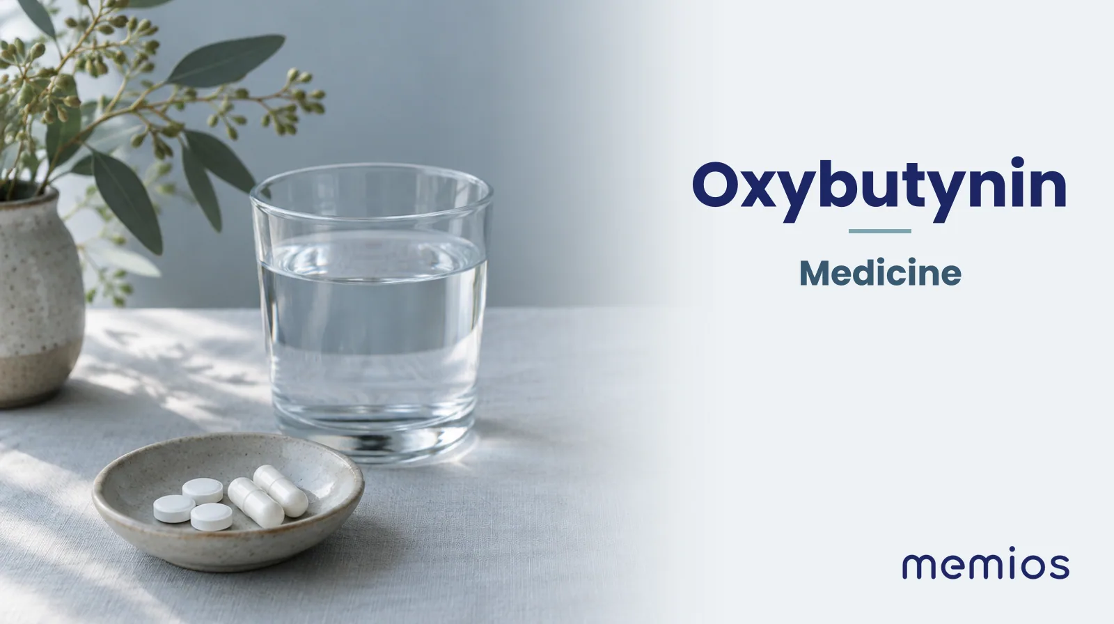 Photograph for Oxybutynin: plain unmarked tablets in a dish beside a glass of water on pale linen.