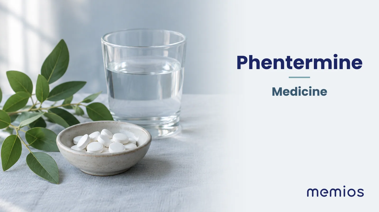Photograph for Phentermine: plain unmarked tablets in a dish beside a glass of water on pale linen.