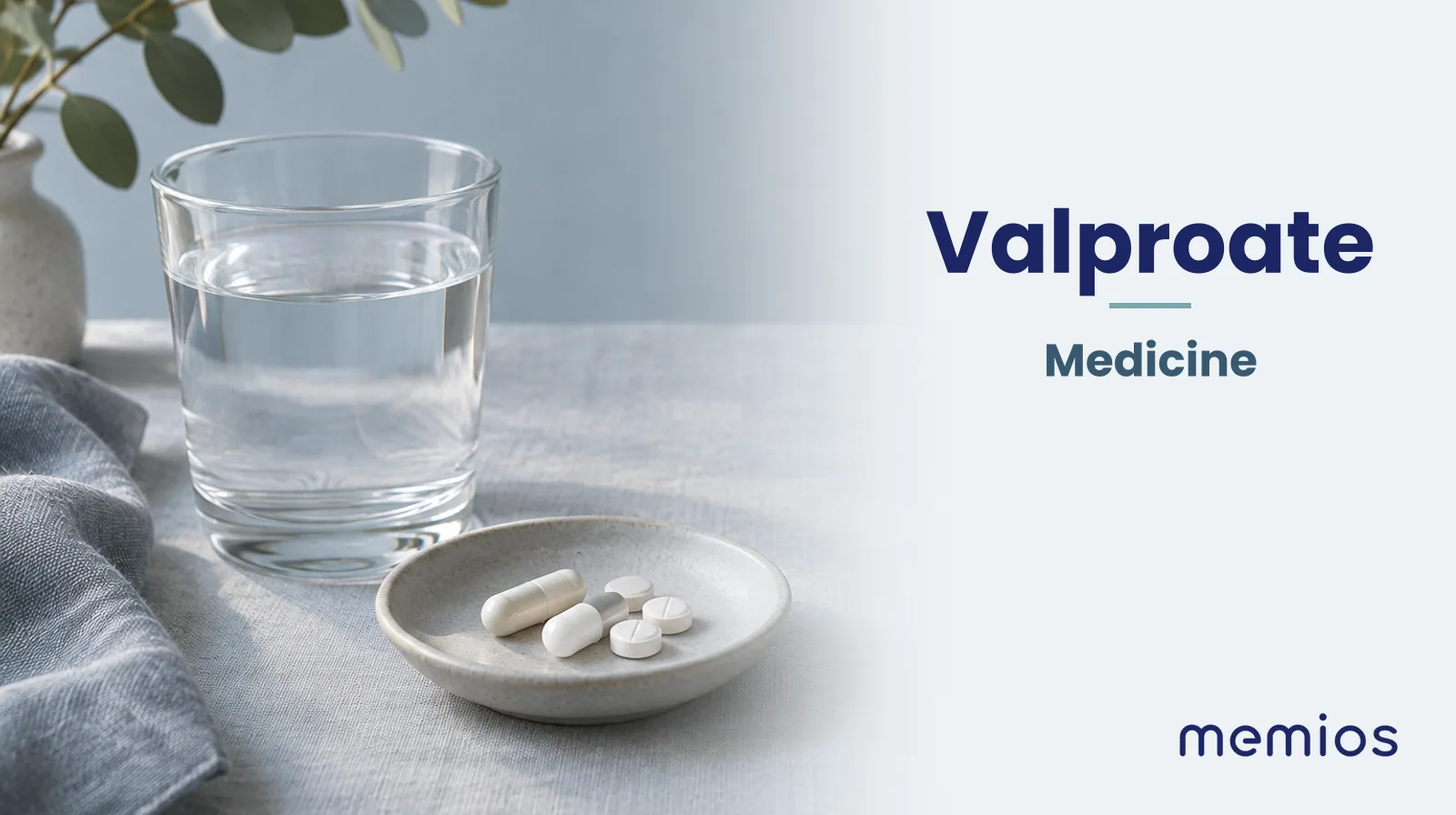 Photograph for Valproate: plain unmarked tablets in a dish beside a glass of water on pale linen.